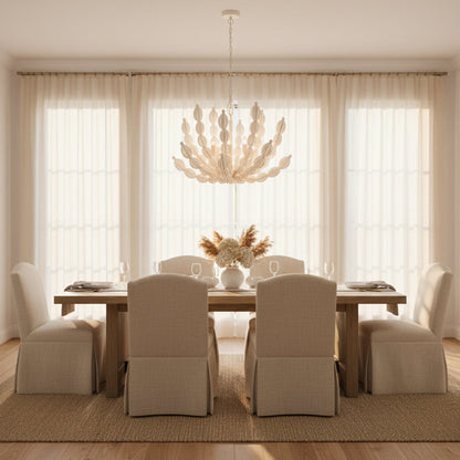 Dining room with a wooden table, beige chairs, and a chandelier.