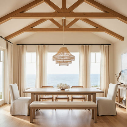 Dining room with wooden table, chairs, and a chandelier in a home with an open ceiling.