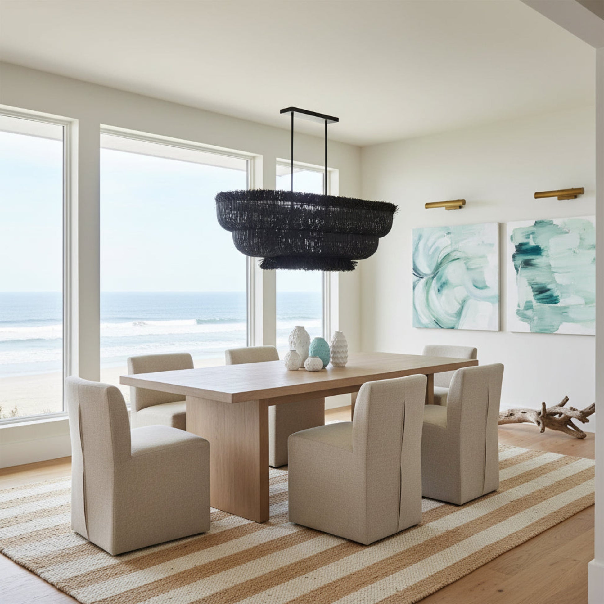 Modern dining room with a large window view, black chandelier, and abstract artwork.