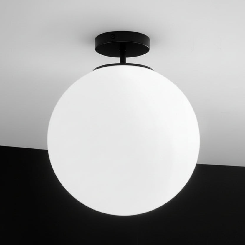 Ceiling light fixture with a spherical white shade on a black and white background