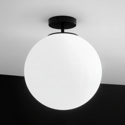 Ceiling light fixture with a spherical white shade on a black and white background